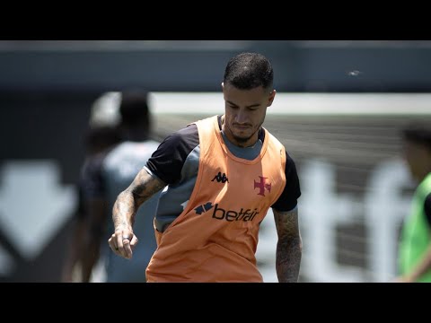 Jogador do Vasco em treino, usando uniforme laranja e camiseta de treino no campo.