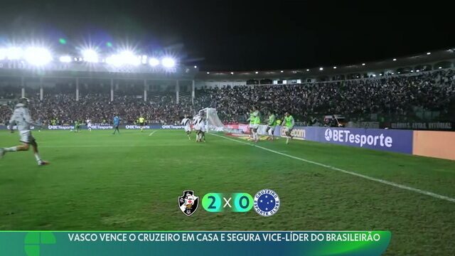 Vasco em destaque no estádio com torcida ao fundo.