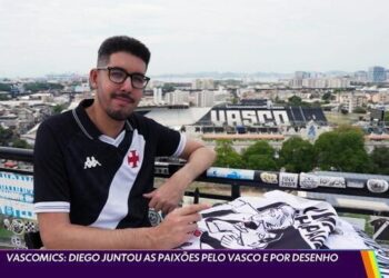 Homem com camisa do Vasco na cobertura com vista da cidade.