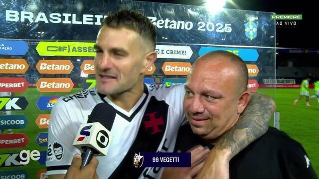 Jogador de futebol sorridente com torcedor após jogo.