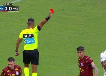 Árbitro mostrando cartão vermelho no campo de futebol.