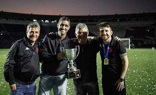 Carlos Brazil comemora o título Carioca ao lado do CEO Luiz Mello (segurando o troféu), o técnico William Batista (à direita) e Eduardo Húngaro (à esquerda)
