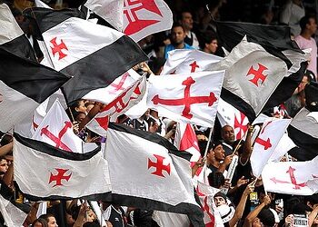 Bandeiras do Vasco sendo hasteadas na torcida.