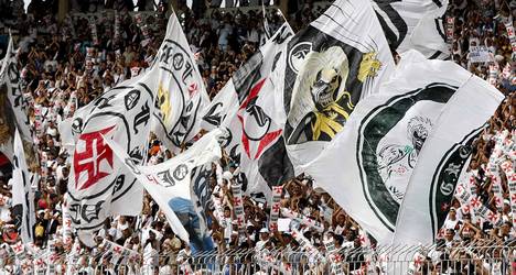 Bandeiras do Vasco sendo agitadas no estádio.