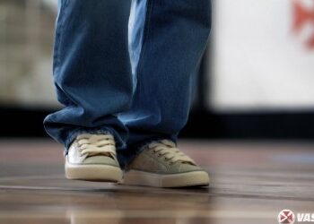 Técnico de futebol com calçados esportivos.