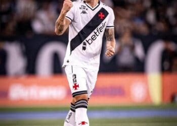 Jogador comemorando gol com força, usando uniforme do Vasco.
