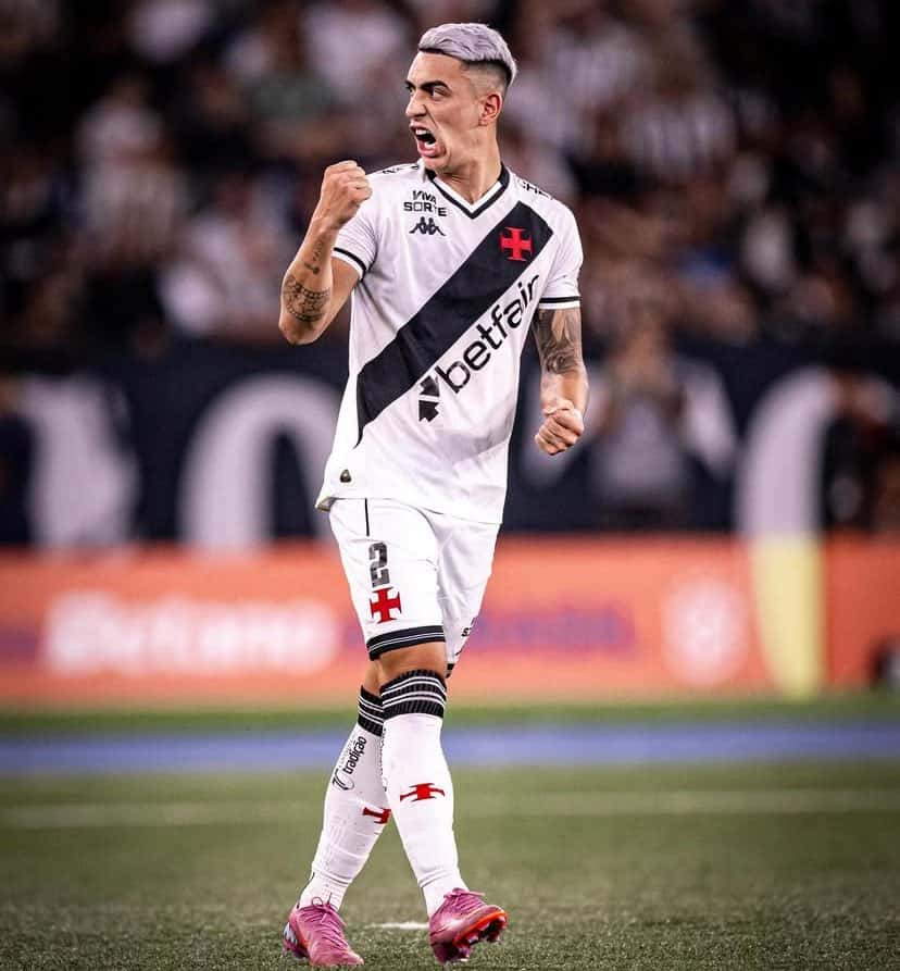 Jogador comemorando gol com força, usando uniforme do Vasco.