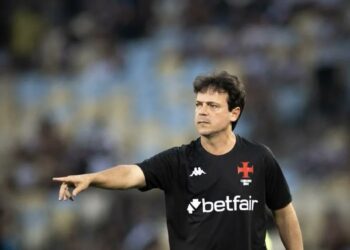 Futebolista apontando em campo.