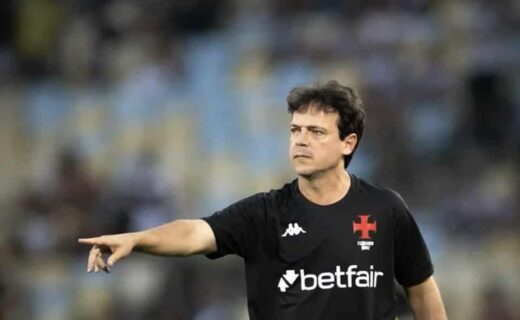 Futebolista apontando em campo.