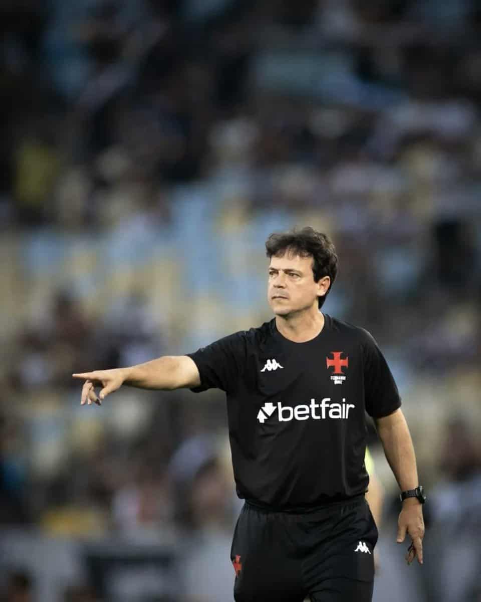 Futebolista apontando em campo.