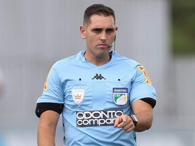 Árbitro de futebol vestido com uniforme azul claro.