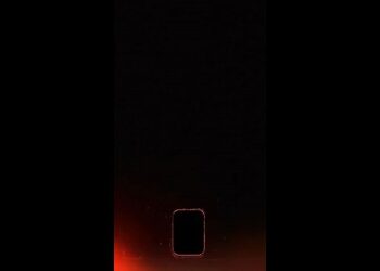 Smartphone com tela apagada em fundo preto com brilho vermelho.