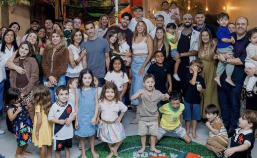 Família comemorando aniversário infantil com crianças e adultos em festa.