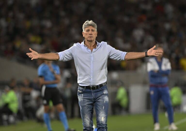 Treinador Vasco com braços abertos em campo.