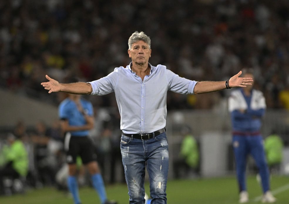 Treinador Vasco com braços abertos em campo.