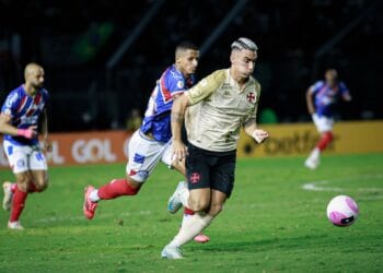 Jogador do Vasco correndo atrás da bola em campo.