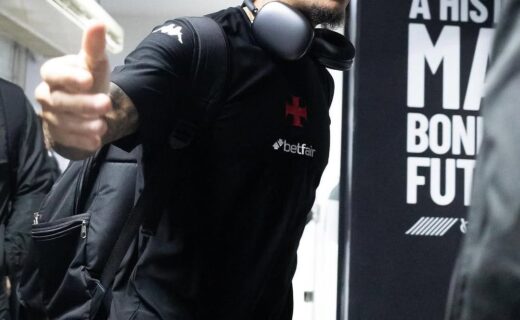 Jogador com mochila e fones de ouvido no aeroporto.