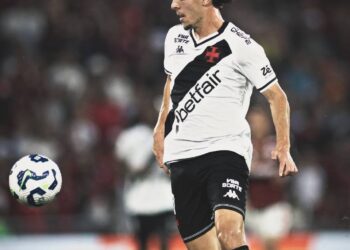 Jogador do Vasco correndo com a bola durante partida.