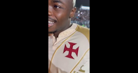 Jogador do Vasco com uniforme branco e escudo vermelho.