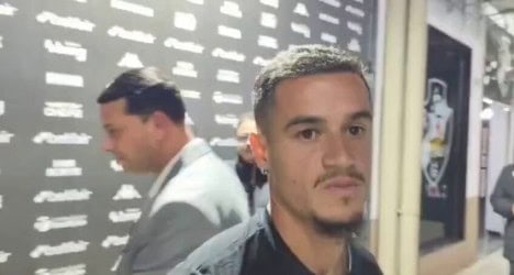 Homem com expressão séria em ambiente interno.