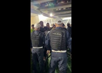 Seres policiais em ação em local fechado.