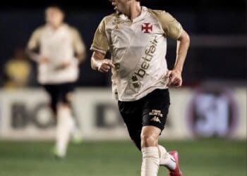Jogador do Vasco driblando com a bola em campo.