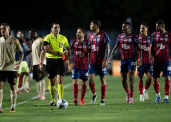 Jogadores do Vasco em campo durante jogo noturno.