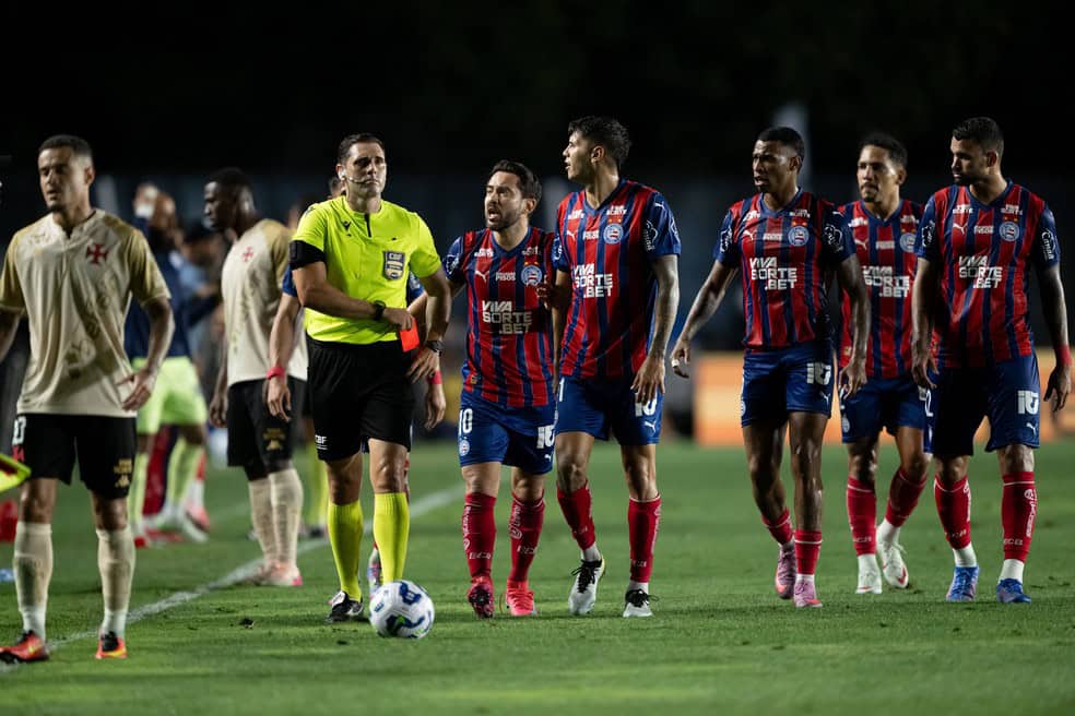 Jogadores do Vasco em campo durante jogo noturno.