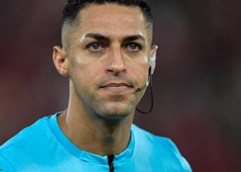 Árbitro de futebol com uniforme azul.