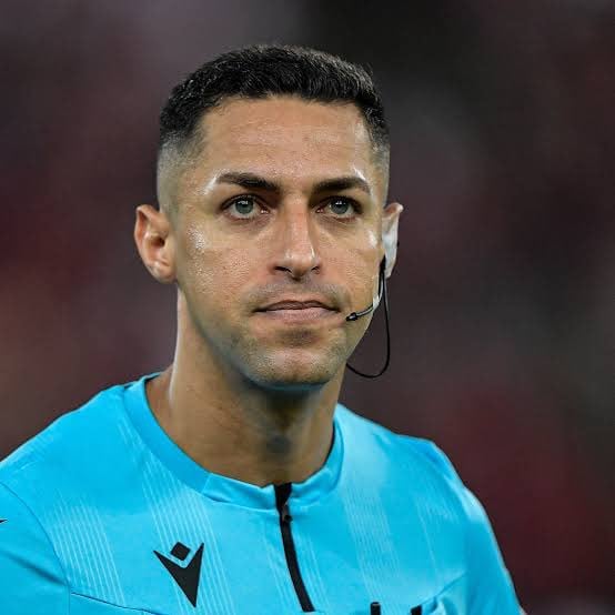 Árbitro de futebol com uniforme azul.