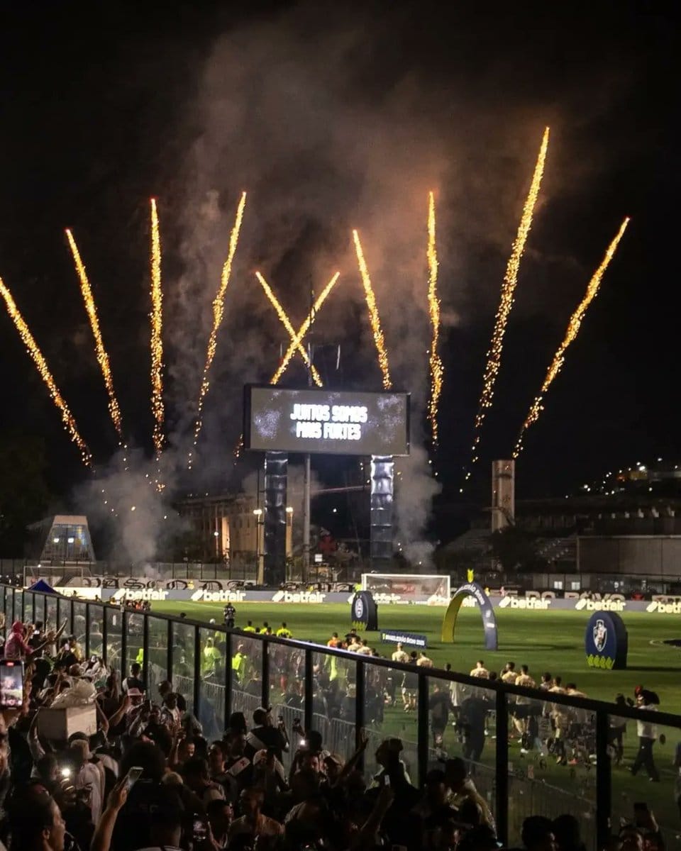 Foguetes iluminando o céu durante partida de futebol.