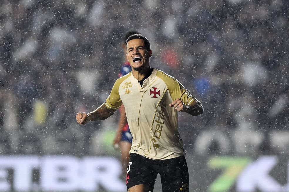 Jogador do Vasco comemorando gol sob chuva.