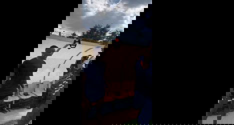 Homem recebendo camisa do Vasco em treino ao ar livre.