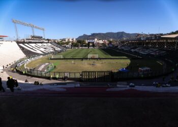 Estádio do Vasco da Gama vazio, com gramado e arquibancadas vistas de dentro.