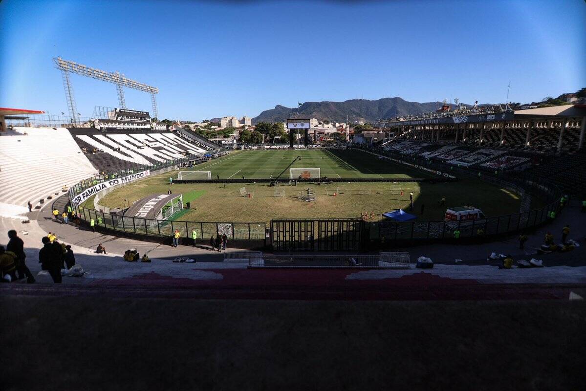 Estádio do Vasco da Gama vazio, com gramado e arquibancadas vistas de dentro.