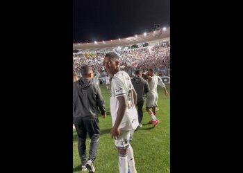 Jogador de futebol no campo à noite.