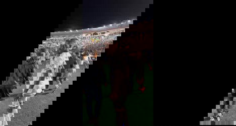 Jogador de futebol no campo à noite.