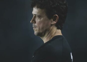 - FOTO DE HOMEM COM CABELO ESCURO, OLHAR FIXO E EXPRESSÃO Séria.