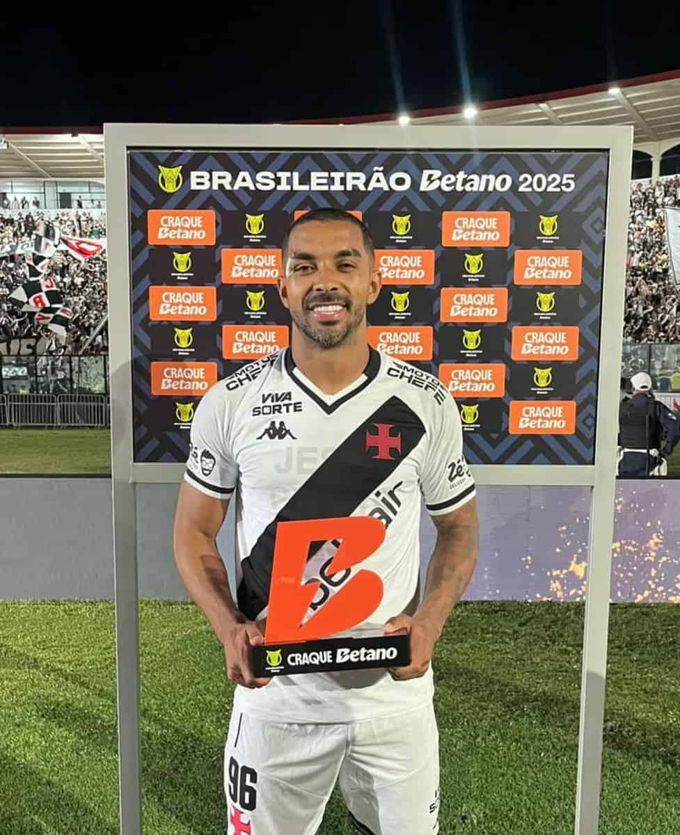 BRAZILIAN SOCCER PLAYER APPEARS WITH VASCO JERSEY AND TROPHY AT CEREMONY.