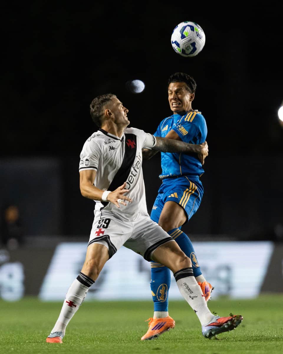 Jogadores de futebol brigando pelo bola em campo.