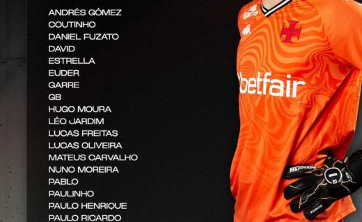Jogador de futebol com uniforme laranja e luvas pretas.