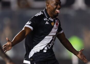 Jogador de futebol comemorando gol em campo.