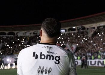 Jogador visto de costas no estádio durante a partida.