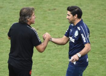 Aprimés à bord du terrain de football, deux hommes échangent une poignée de main amicale.
