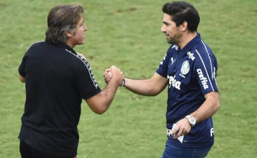 Aprimés à bord du terrain de football, deux hommes échangent une poignée de main amicale.