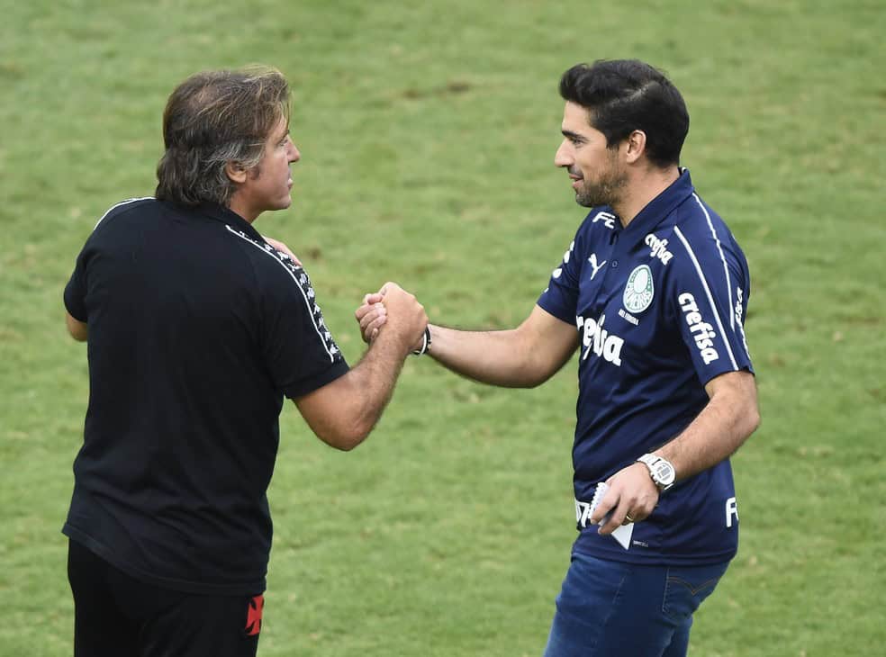 Aprimés à bord du terrain de football, deux hommes échangent une poignée de main amicale.