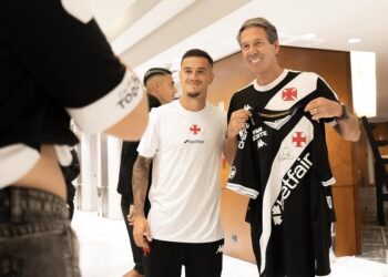 De jogadores do Vasco segurando uniforme oficial.