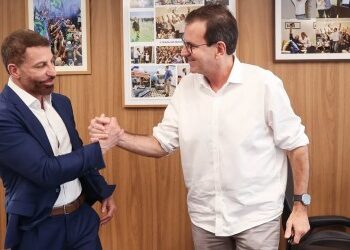 Famosos trocando aperto de mão em reunião.