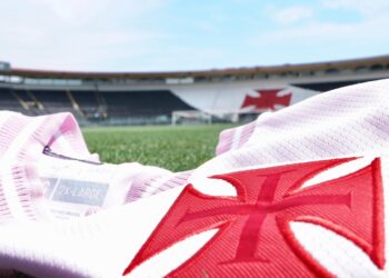 Botas de futebol do Vasco com estádio ao fundo.