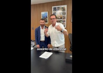 Homens conversando em sala de reunião.